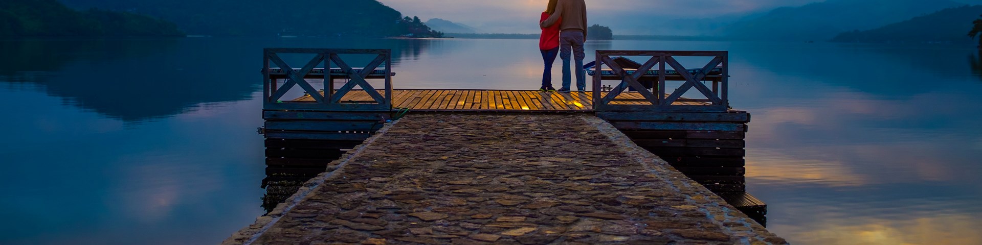 A couple relaxing in front of a lake