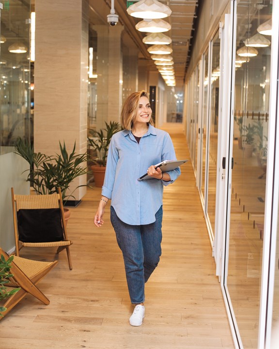 A lady walking down a corridor in a business